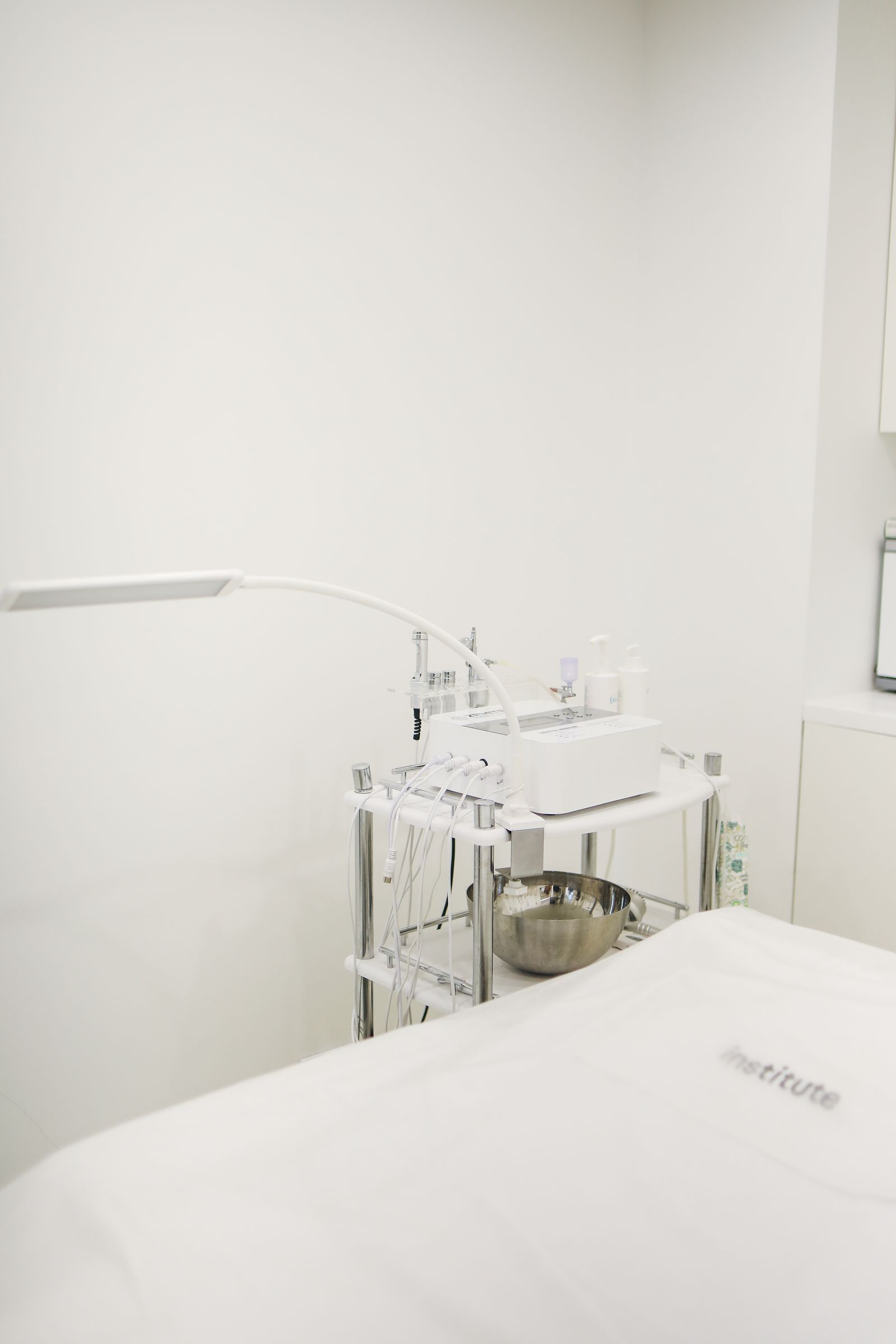 A white skin-therapy suite with treatment equipment beside the bed
